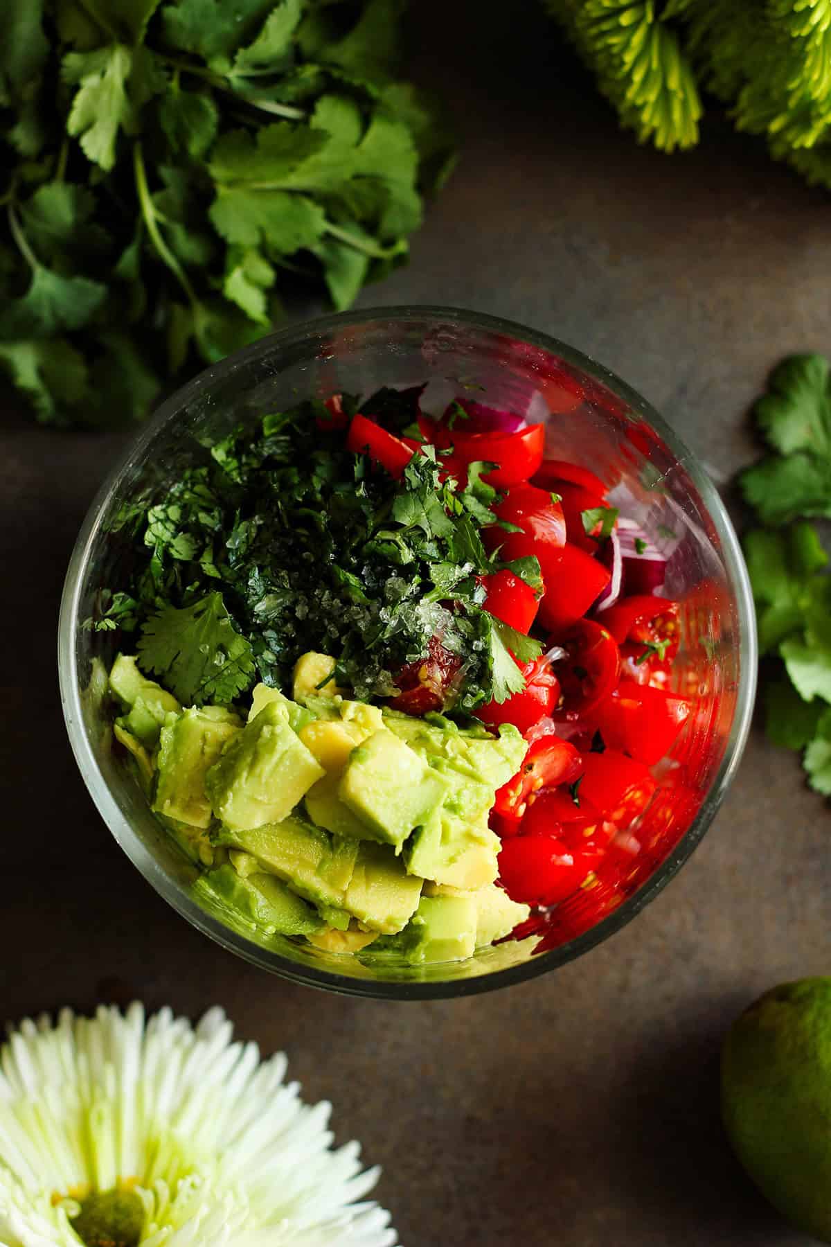 ingredients for tomato avocado salad added to a bowl