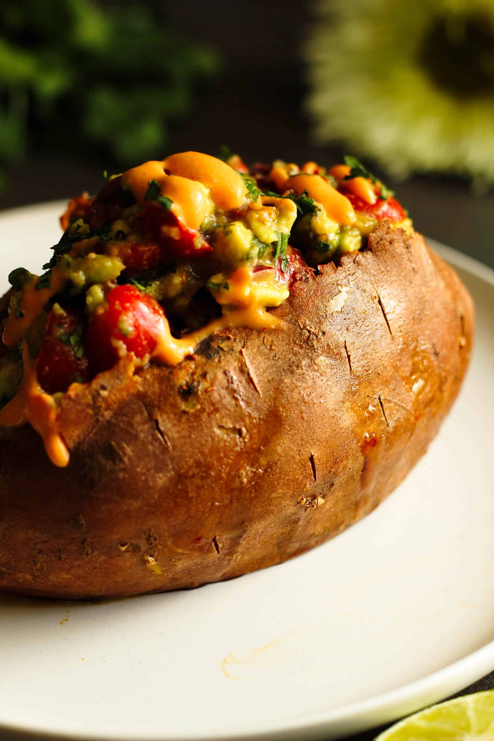 close-up of stuffed sweet potato with ground chicken taco meat and creamy chipotle sauce