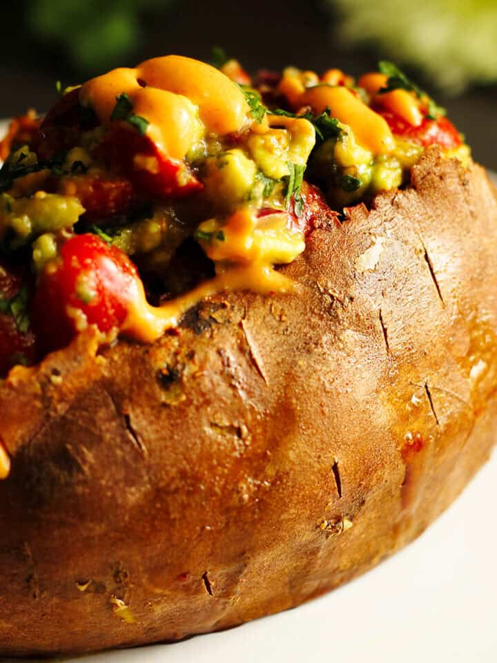taco stuffed sweet potatoes with avocado salad and chipotle sauce