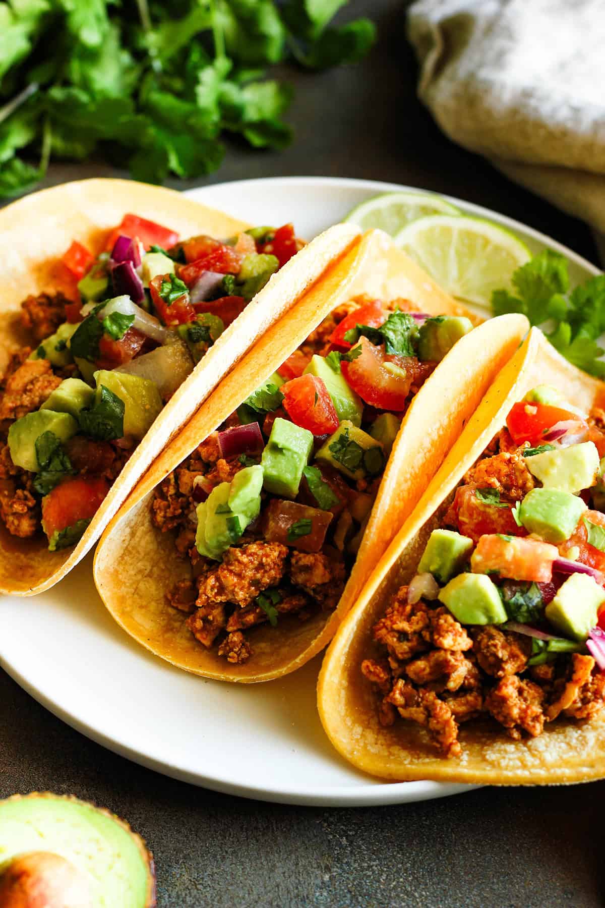 three ground chicken tacos with avocado salsa